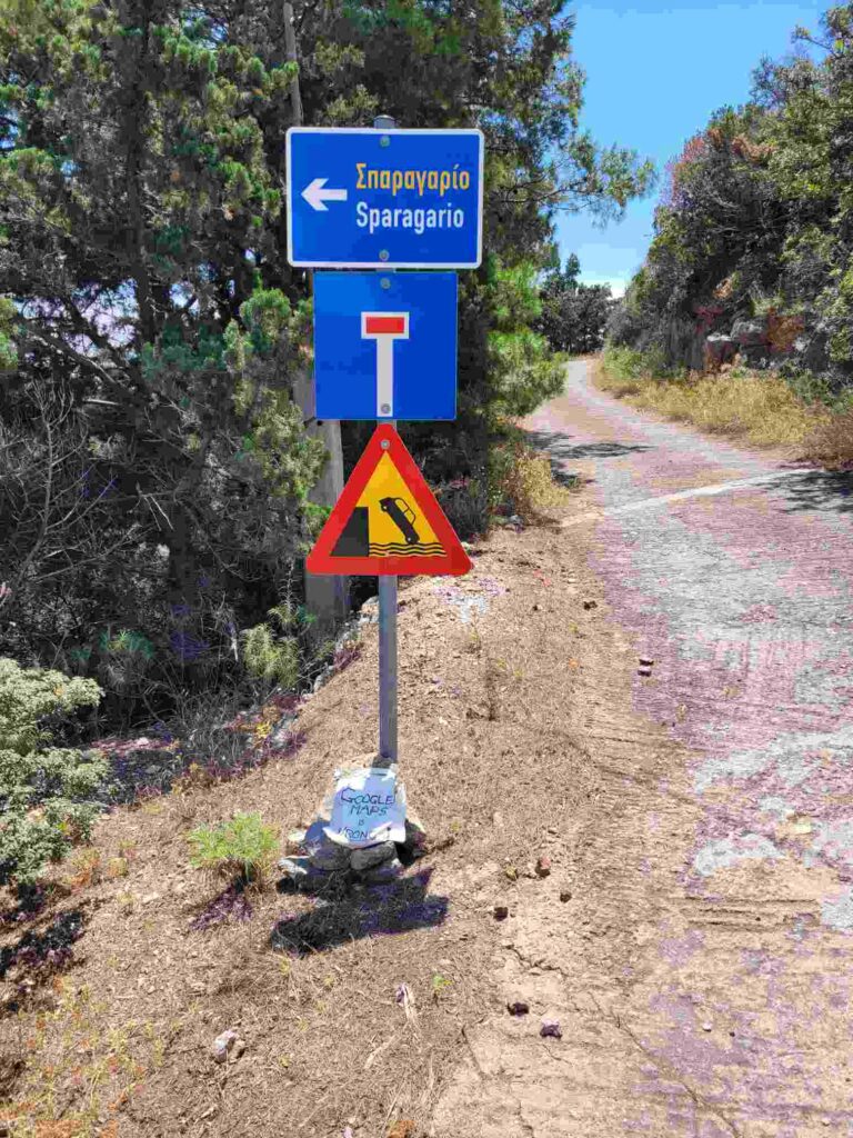 Roadtrip Griechenland - Warnschild Auto fällt ins Wasser mit Stein und Aufschrift Google Maps is wrong