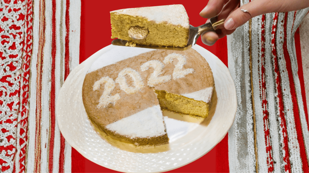 Angeschnittene Vasilopita mit Puderzucker und Neujahrsdeko